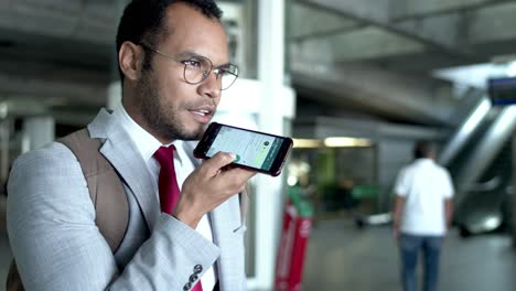 Businessman-with-backpack-talking-by-smartphone